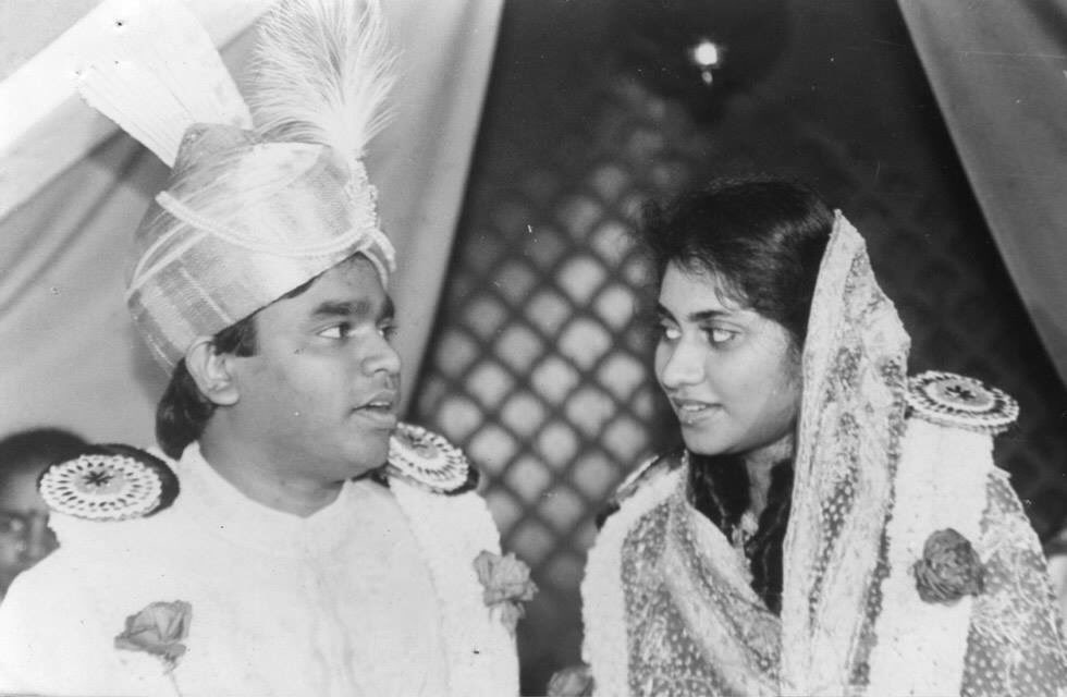 Black and white photo of a man in a turban and a woman in a sari looking at each other.