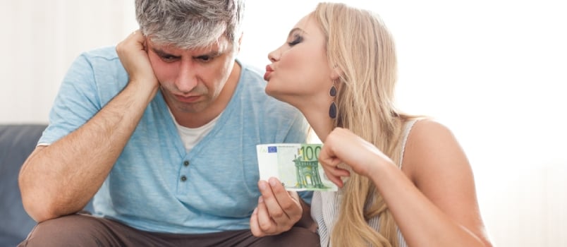 A woman attempts to cheer up a sad man while holding a Euro banknote.