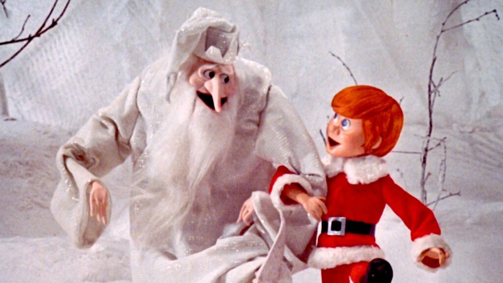 Two animated characters, one dressed in a white frosty costume and the other in a red Santa outfit, in a snowy setting.