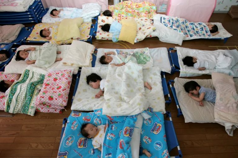 Children lying on mats and sleeping during nap time at a daycare center.