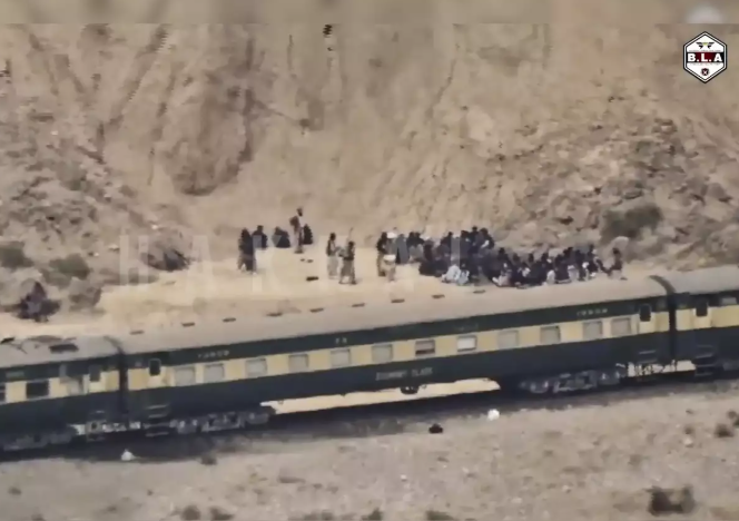 Balochistan train attack: Jaffar Express driver recalls how insurgents attacked train in Pakistan. Pakistan still hiding facts 2 Train in Desert Landscape::Aerial view of a train alongside a group of people gathered in a desert setting.