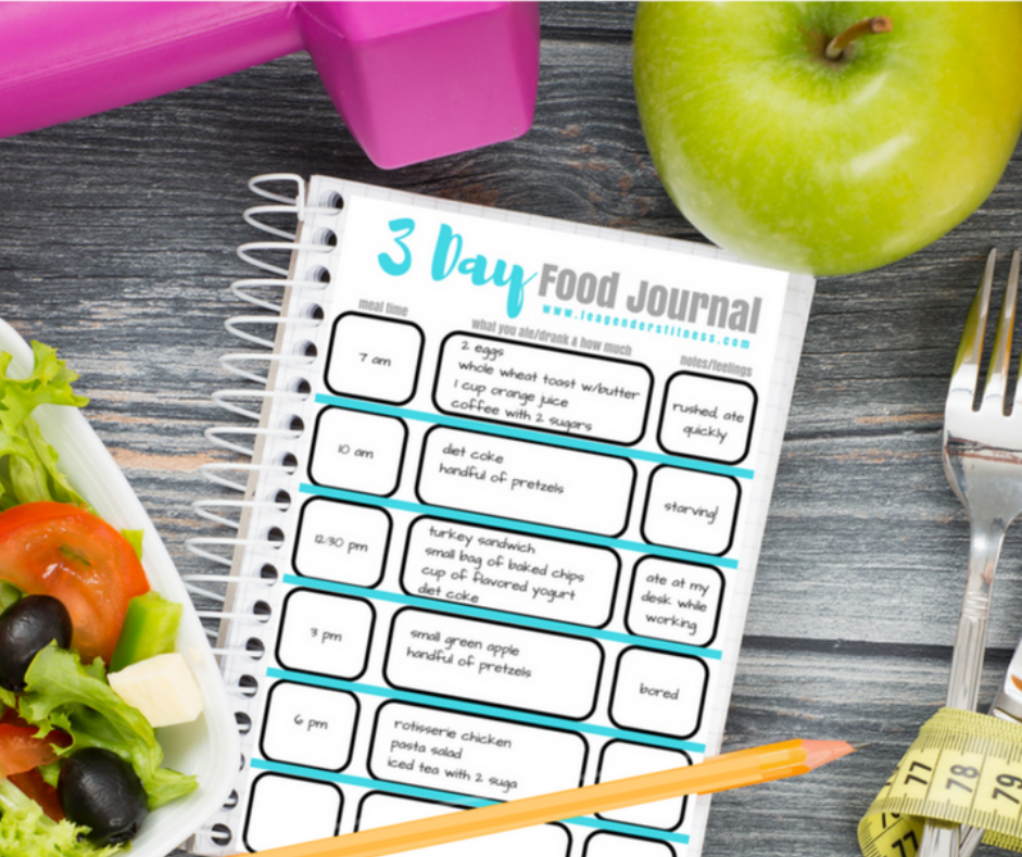 15 Research-backed methods for losing weight without exercise 6 A colorful food journal with a meal schedule and notes section alongside a salad, green apple, dumbbell, and measuring tape on a wooden table.