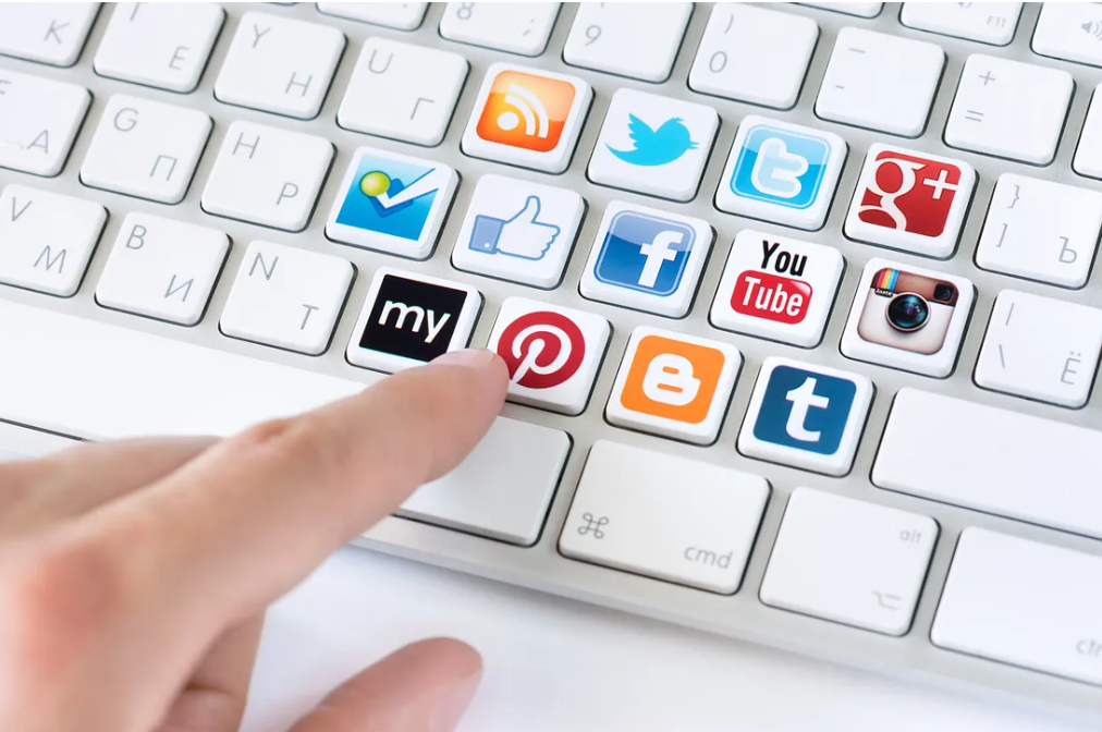 Habits to Avoid That Drain Your Energy Everyday 3 A close-up of a keyboard featuring popular social media icons, with a finger poised to press the Pinterest key.