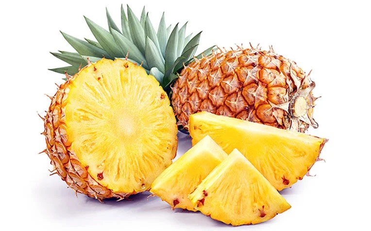 Four Fruits We Shouldn't Make Jiuce Of 3 Fresh whole and sliced pineapple on a white background, showcasing its vibrant yellow interior and spiky exterior.