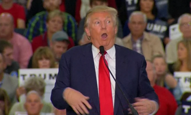 Donald Trump animatedly speaking at a rally with a captivated audience in the background