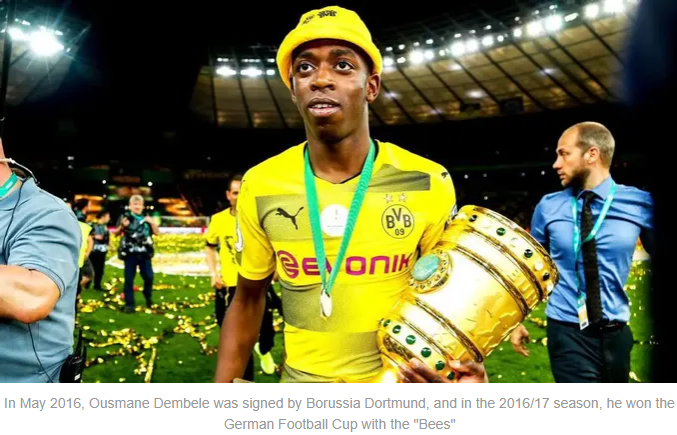 Ousmane Dembélé holding the German Football Cup, wearing Borussia Dortmund's yellow jersey, amidst celebratory confetti and teammates in the background.