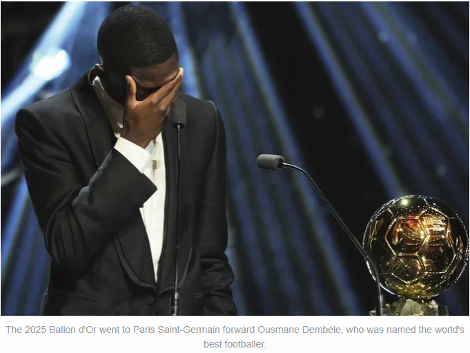 Ousmane Dembele expresses emotion after winning the Ballon d'Or, holding back tears while standing beside the trophy.